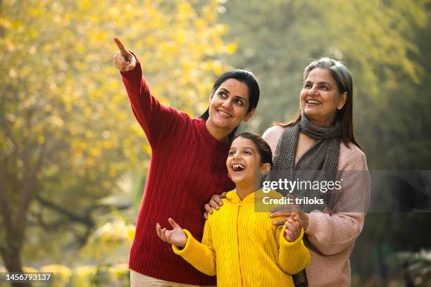 fröhliche indische familie, die die aussicht auf den park bewundert - indian girl pointing stock-fotos und bilder