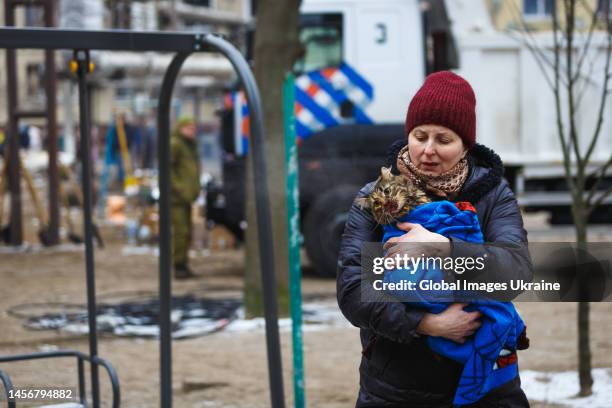 Woman holds a cat rescued from a high-rise residential building hit by a missile on January 15, 2023 in Dnipro, Ukraine. On January 14, Russia...