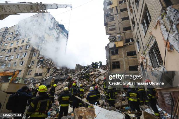 Rescuers search people trapped under the rubble of a high-rise residential building hit by a missile on January 15, 2023 in Dnipro, Ukraine. On...