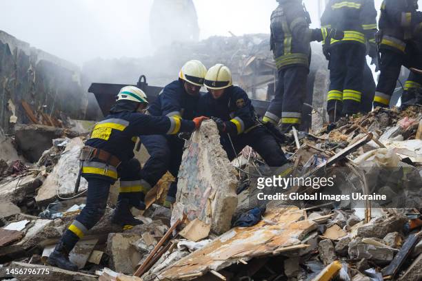 Rescuers search people trapped under the rubble of a high-rise residential building hit by a missile on January 15, 2023 in Dnipro, Ukraine. On...