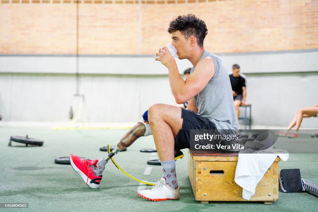 Caucasian fitness man hydrate with water after training on athletics track at stadium