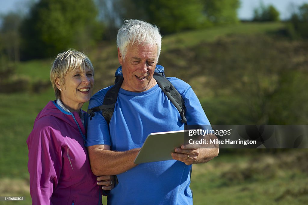 Retired Walking Couple Using Digital Tablet