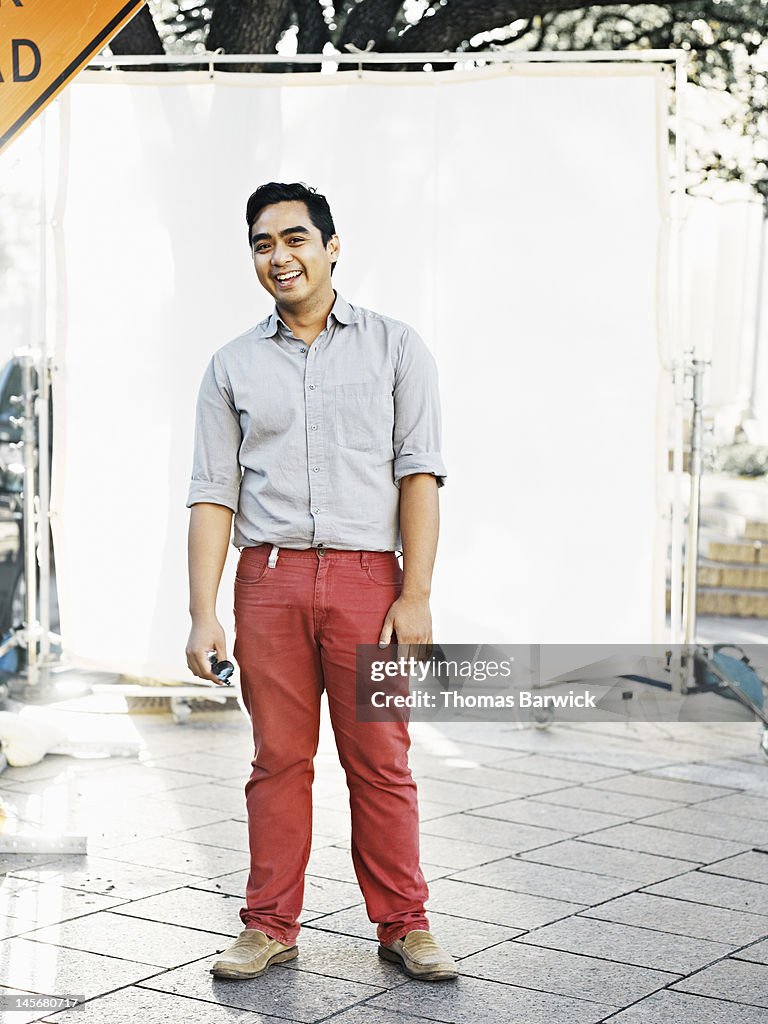 Man standing against white background laughing