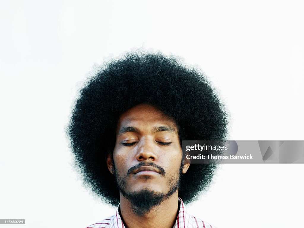 Man with afro hairstyle eyes closed chin up