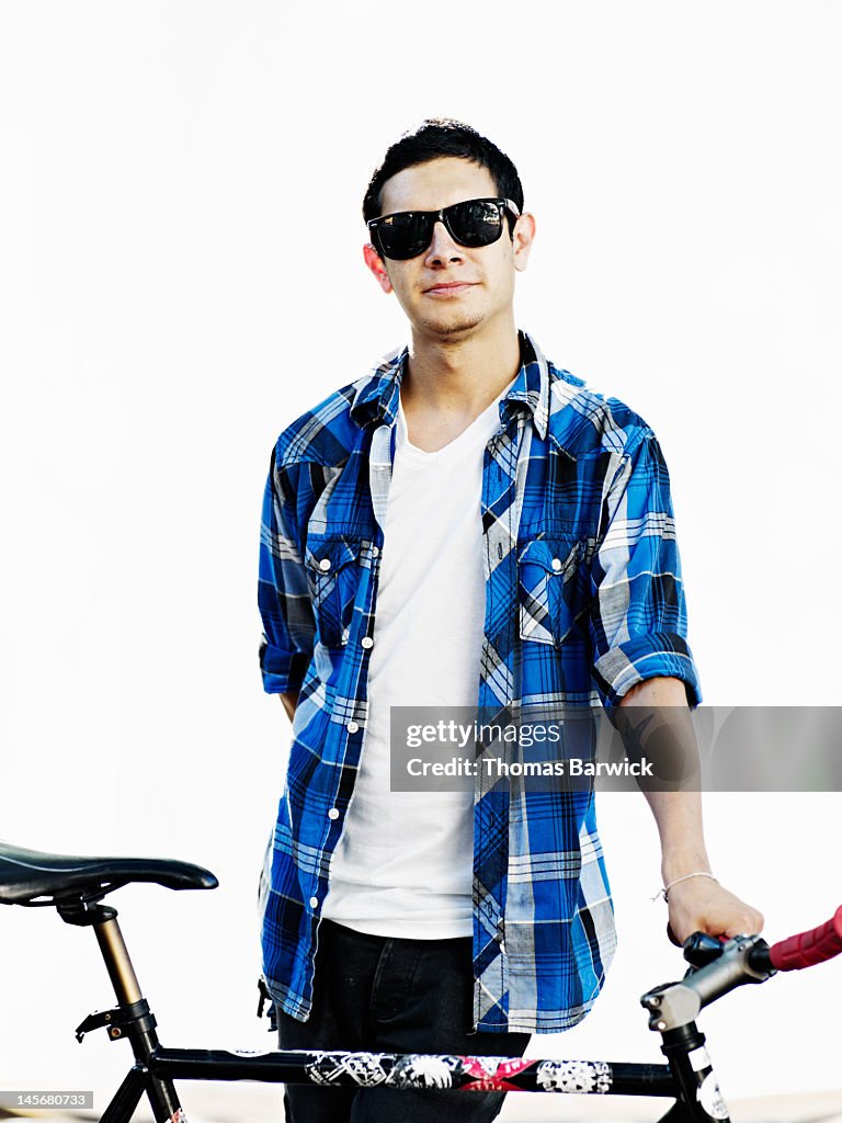 Man wearing sunglasses holding bicycle