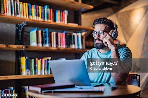 estudiante masculino usando computadora portátil en la biblioteca - male professor with students fotografías e imágenes de stock