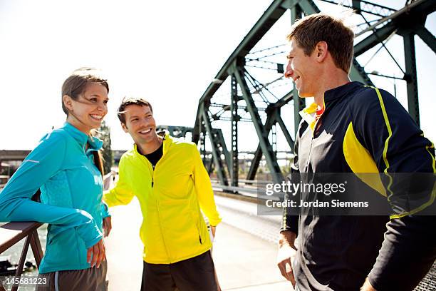 a group of runners stretching on a bridge. - newfriendship stock pictures, royalty-free photos & images