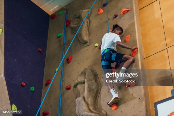 boy on climbing wall - high stock pictures, royalty-free photos & images