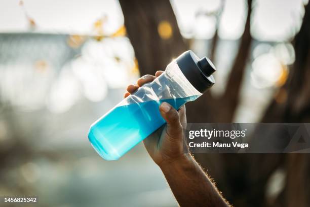 crop black athlete drinking sports hydration drink from bottle - energydrink stock-fotos und bilder