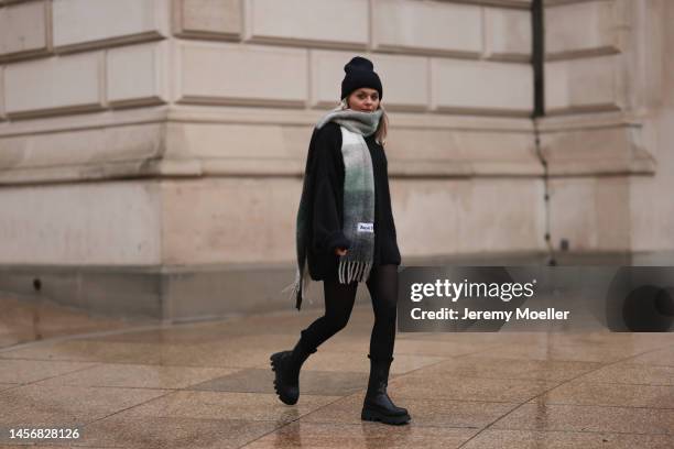 Sarah wearing a black jacket, black Aylin Koenig turtleneck sweater, black Copenhagen studios leather boots, green Acne studios scarf and a black...