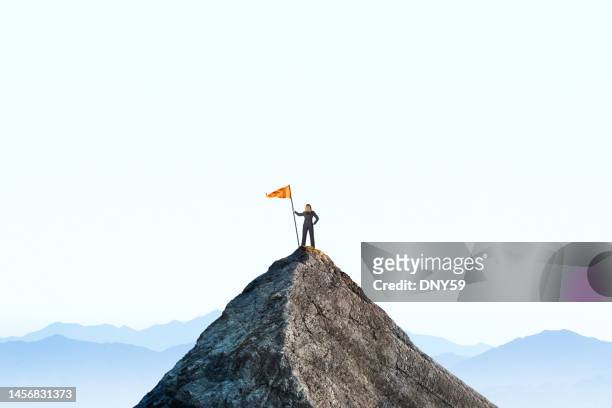 woman planting a flag on a mountain peak - vlag planten stockfoto's en -beelden
