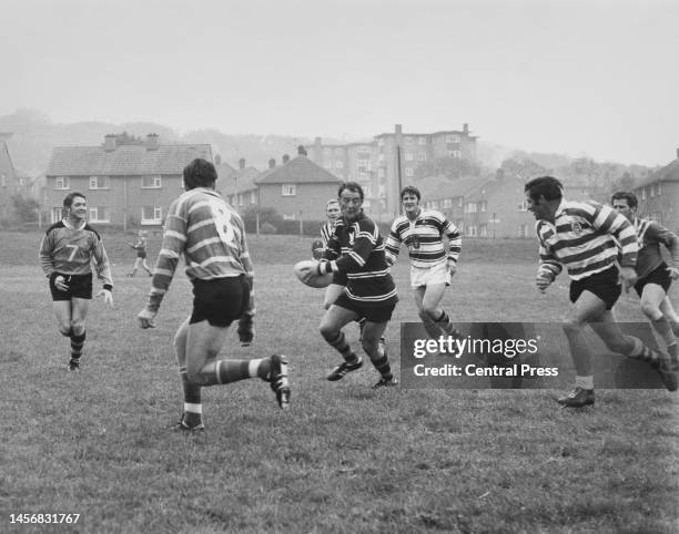Ken Arthurson, manager of the Australian rugby league team runs with the ball and prepares to pass to Ron Costello during a training session for the...