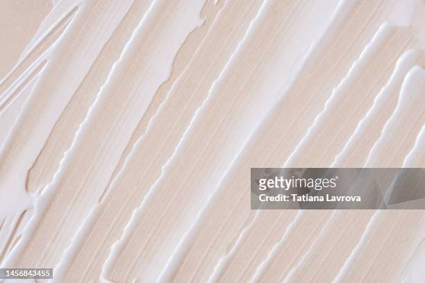 smears of white face cream in macro. close up of pastel colored beauty product with copy space - beige wallpaper stock pictures, royalty-free photos & images