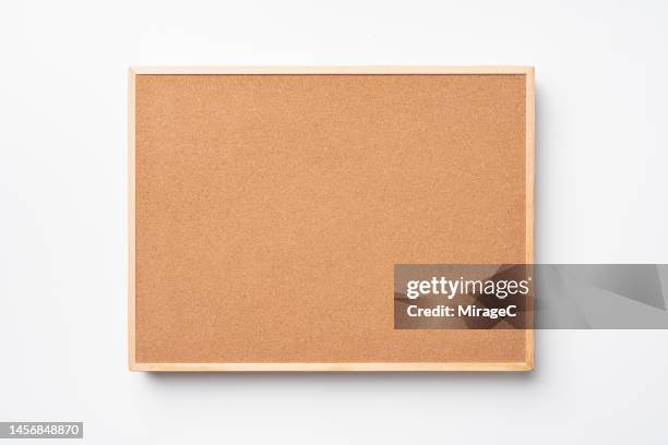 blank cork board hanging on white wall front view - anschlagbrett stock-fotos und bilder