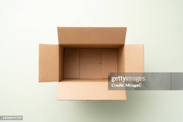 opened empty cardboard box on green background - open land stock pictures, royalty-free photos & images