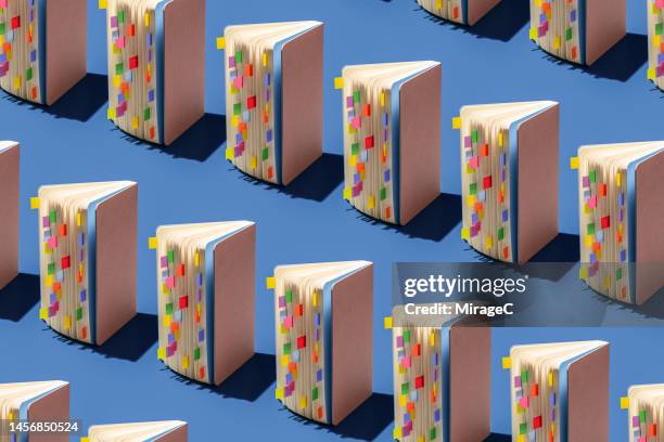 opened note pads with colorful bookmarks repetition pattern - continuous learning stock pictures, royalty-free photos & images