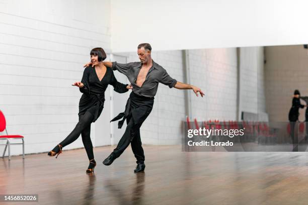 hermosa pareja bailando jive juntos en un área de ensayo - swing dance fotografías e imágenes de stock