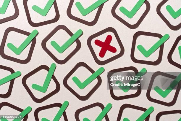 a single cross mark stands out from many check marks - mistake stock pictures, royalty-free photos & images