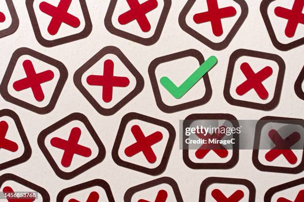a single check mark stands out from many cross marks - abundance stock pictures, royalty-free photos & images