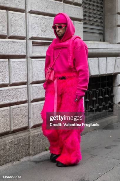 Guest is seen wearing pink fur coat, pink hoodie, pink beanie and pink sunglasses and crossbody bag outside the Giorgio Armani show during the Milan...