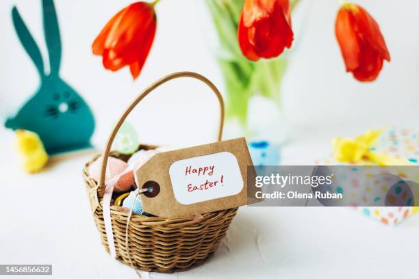 happy easter tag and eggs in a basket, easter bunny, tulips, gift box. - easter basket stock pictures, royalty-free photos & images