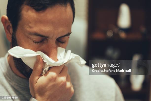cool man in house blowing his nose - mouchoir photos et images de collection