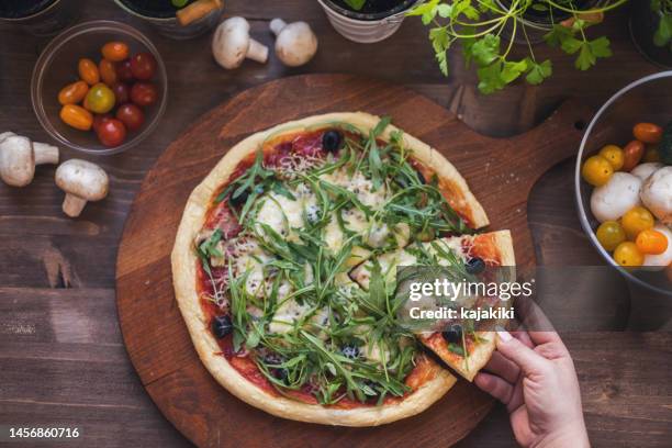 freshly baked homemade prosciutto and arugula pizza with olives and mozzarella cheese - flatbread pizza stock pictures, royalty-free photos & images