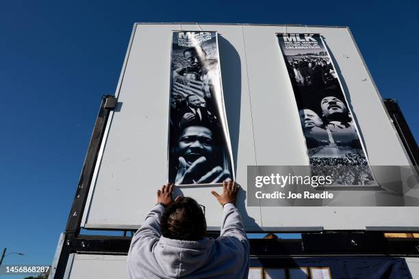 David Bynes places posters on the Florida International University float during the Dr. Martin Luther King Jr. Day Parade in the Liberty City...