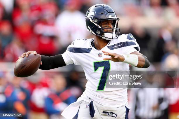 Geno Smith of the Seattle Seahawks throws a pass against the San Francisco 49ers during the first half of the game in the NFC Wild Card playoff game...