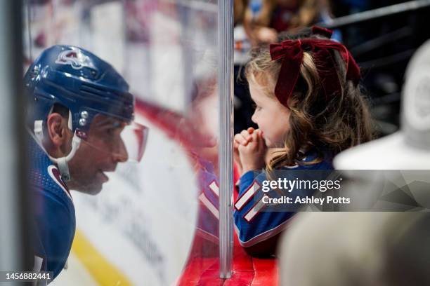 Andrew Cogliano of the Colorado Avalanche says hi to his daughter through the glass during warmups ahead of the game against the Detroit Red Wings at...