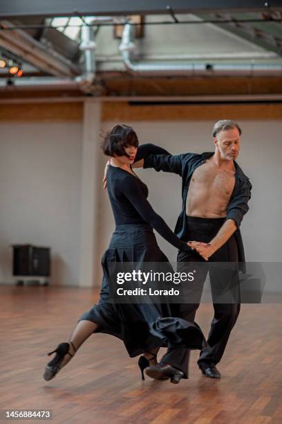 schönes paar tanzt tango in einem proberaum - tango tanz stock-fotos und bilder