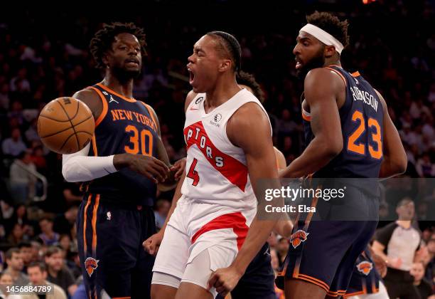 Scottie Barnes of the Toronto Raptors celebrates his dunk as Julius Randle and Mitchell Robinson of the New York Knicks look on during the first half...