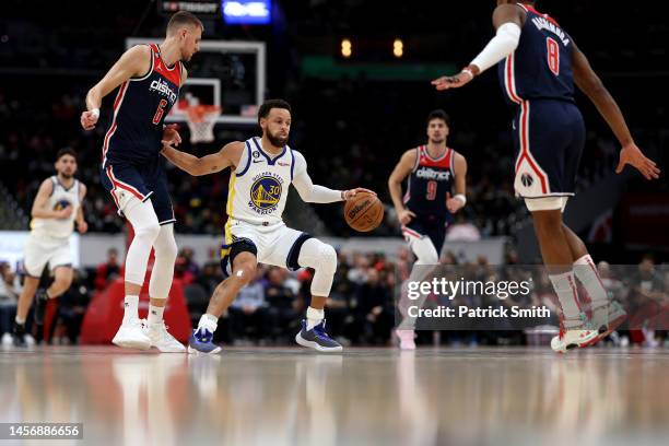 Stephen Curry of the Golden State Warriors dribbles in front of Kristaps Porzingis of the Washington Wizards during the first half at Capital One...