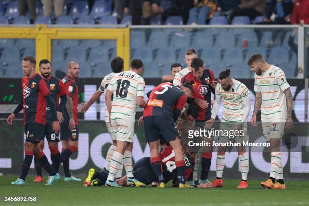 Team mates look on as Alessandro Vogliacco of Genoa CFC falls to the ground clutching his face following a clash with Ridgeciano Haps of Venezia FC...