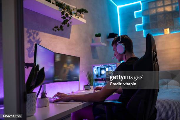 teenage boy playing multiplayer games on desktop in his room - computer gaming stock pictures, royalty-free photos & images