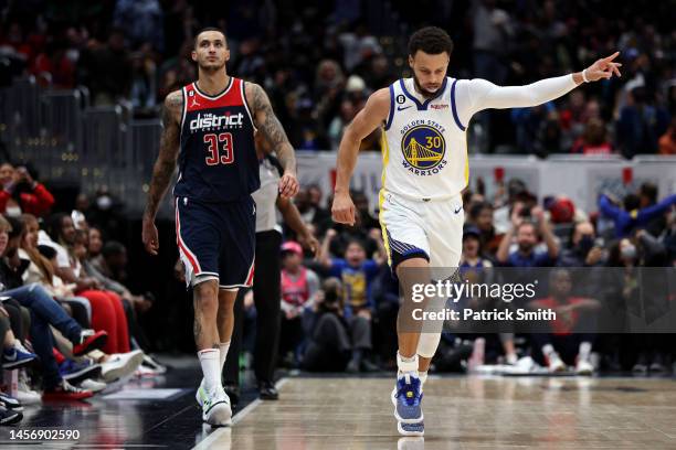 Stephen Curry of the Golden State Warriors celebrates after scoring in front of Kyle Kuzma of the Washington Wizards during the second half at...