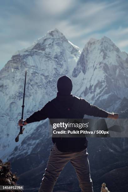 rear view of man standing against snowcapped mountains,dingboche,nepal - glimpses of daily life in nepal stock pictures, royalty-free photos & images