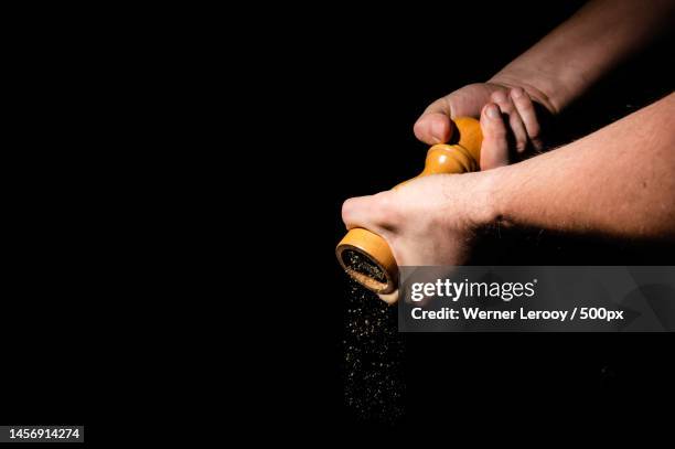 cook turning a pepper mill against a black background,belgium,brussels - pepper mill stockfoto's en -beelden