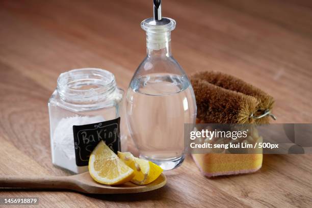 white vinegar baking soda and lemon on wooden table top,malaysia - vinegar stockfoto's en -beelden