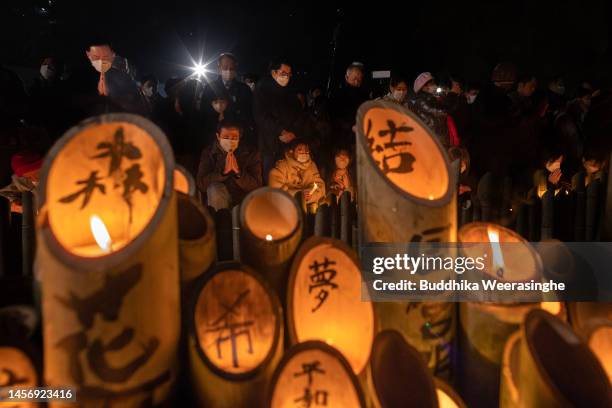 People pray at 5:46 a.m. In memory of the victims of the Great Hanshin Earthquake in front of the candle-lit bamboo lanterns, marking the 28th...