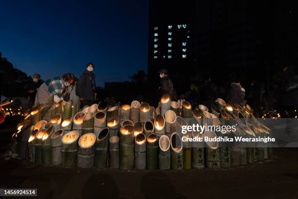 Woman lights bamboo lanterns in prayer for the victims of the Great Hanshin Earthquake, marking the 28th anniversary at Higashi Yuenchi Park on...