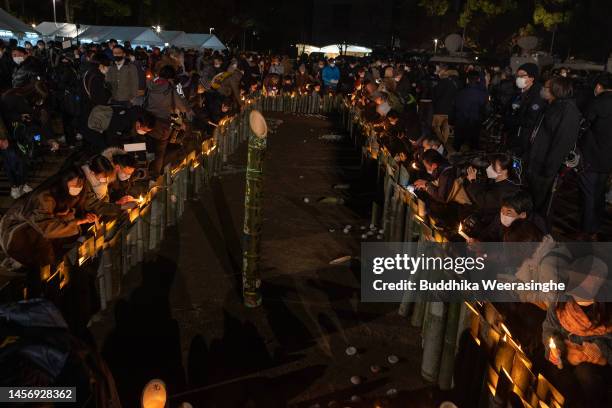 People pray for the victims of the Great Hanshin Earthquake in front of the candle-lit bamboo lanterns, marking the 28th anniversary at Higashi...