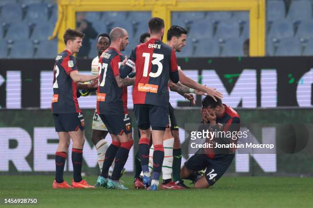 Team mates look on as Alessandro Vogliacco of Genoa CFC falls to the ground clutching his face following a clash with Ridgeciano Haps of Venezia FC...