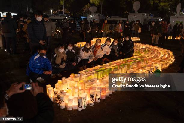 Youngsters pose in front of the candle-lit lanterns during a memorial ceremony to commemorate the 28th anniversary of the 1995 Great Hanshin...