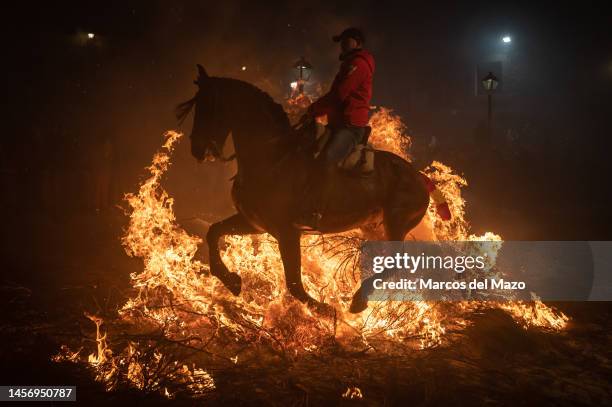 Horse rider jumps over a bonfire on January 16, 2023 in San Bartolome de Pinares, Spain. Horse riders jump over bonfires during the traditional...