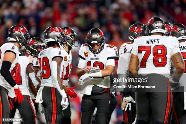 Tom Brady of the Tampa Bay Buccaneers looks on in the huddle against the Dallas Cowboys during the second quarter in the NFC Wild Card playoff game...