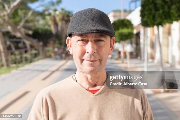 close-up of a happy mature man looking at the camera with the city behind him - head shot close looking stockfoto's en -beelden