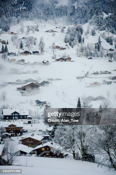 luftaufnahme verschneite berggipfel über traditionellen holzchalet-alpen in grindelwald, schweiz - schweizerische kultur stock-fotos und bilder