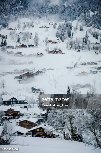 vista aérea de picos nevados sobre los tradicionales alpes chalets de madera en grindelwald, suiza - swiss alps fotografías e imágenes de stock