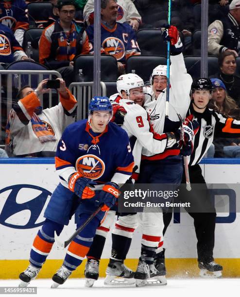 Dmitry Orlov of the Washington Capitals celebrates his game-winning goal in overtime against Ilya Sorokin of the New York Islanders and is joined by...